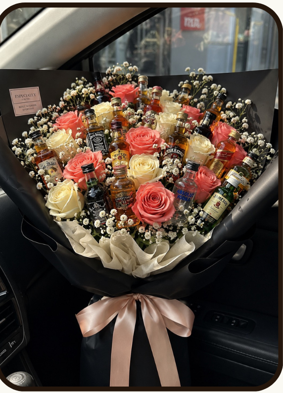 Promotional graphic for a floral gift set from DrapedNuts, labeled 'Double Barrel Edition' with a bouquet photo and a list of included flowers and bottles. The bouquet contains black and white roses, jagermeister, ballentine, jack Daniel, indri, red label, Bacardi, chivas, and other floral elements, with a pink ribbon.