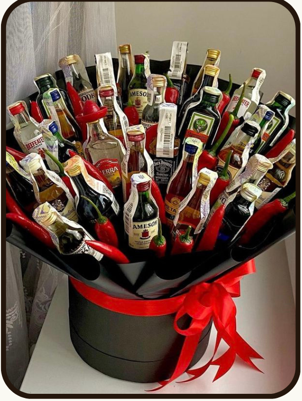 A product listing graphic for a 'Draped Nuts' luxury gift bouquet made of 19 liquor bottles arranged in a black bucket with a red ribbon. The graphic includes a 'What's Inside' list, product details, and pricing in Indian Rupees.